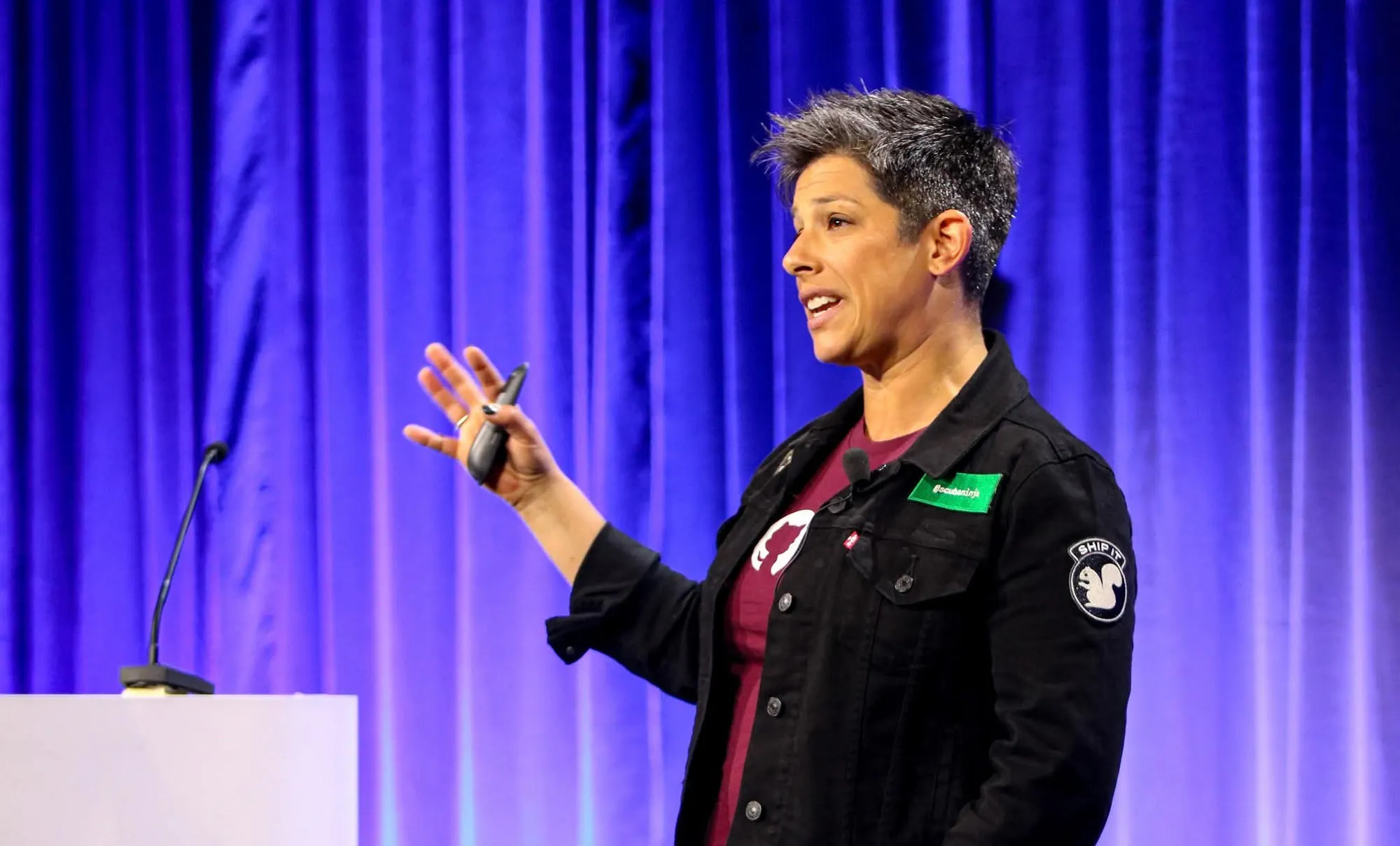 April Yoho speaking against a blue and purple backdrop